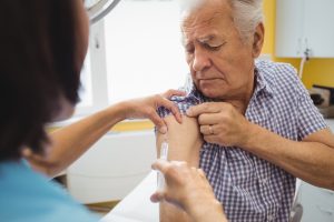 An older man receiving a Covid-19 booster vaccine